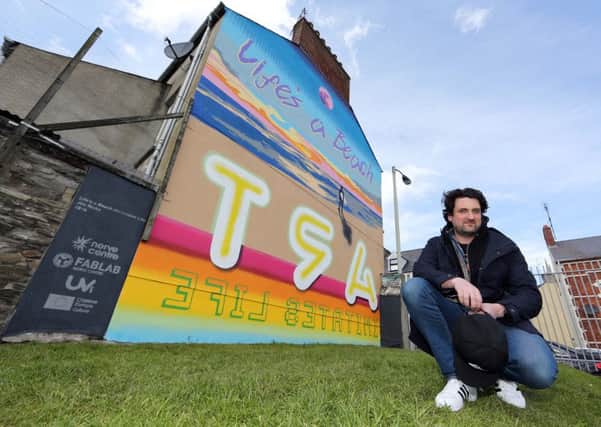 Dublin based American artist, Jim Ricks, pictured beside his new mural on the Abercorn Road.