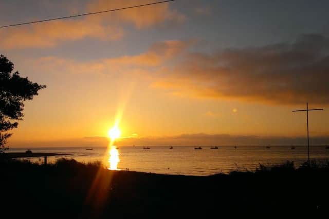 The sunrise over Lough Foyle and County Derry in the distance from Quigley's Point, Inishowen, County Donegal.