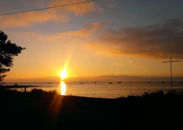The sunrise over Lough Foyle and County Derry in the distance from Quigley's Point, Inishowen, County Donegal.