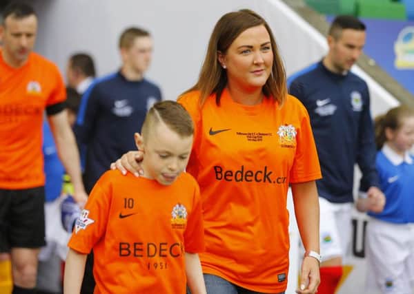 Mark Farren's widow, Terri-Louise Farren leads the teams out on to the pitch at Windsor Park. Picture - Kevin Scott / Presseye