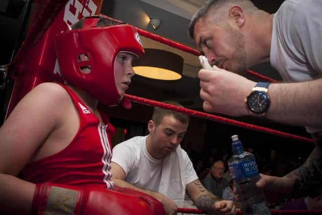 One of the young boxers gets advice from his corner before the last round of his bout on Friday night. DER1816MC007