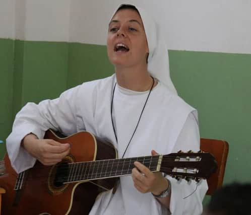 Sister Clare playing her guitar.