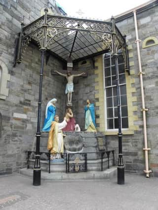 St Columba statue at the foot of the Cross outside St Columba's Church, Long Tower, Derry.