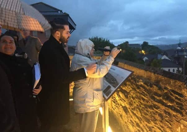 Helen Deery, sister of Manus Deery who was shot dead by a British soldier from this position on the city's walls on May 19, 1972, pictured during a reconstruction of the shooting on Tuesday night. She is looking through a similar type of scope used by the British Army at the time, although it is disputed that any telescopic viewing equipment was used at all. Helen is accompanied by solicitor Richard Campbell of from Quigley, Grant and Kyle.