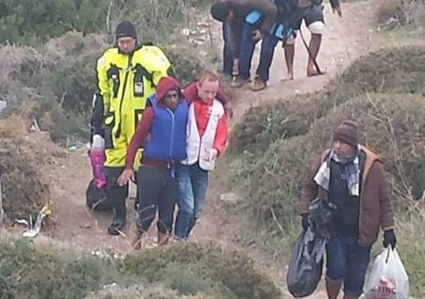 A man in a life-jacket is supported off the boats and on to dry land at Lesvos, Greece (pic: Hilda Orr).