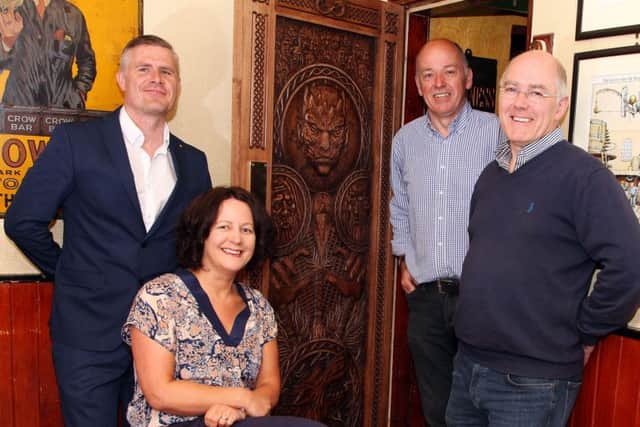 Ciaran Doherty, Tourism Ireland; Orla Farren, Tourism NI; Damian and Garry Owens, Frank Owens Bar, beside the intricately carved door which depicts scenes from episode five of series six  a feature of Tourism Irelands 2016 Game of Thrones campaign  which is hanging in Frank Owens Bar in Limavady. Pic by: Paul Nash