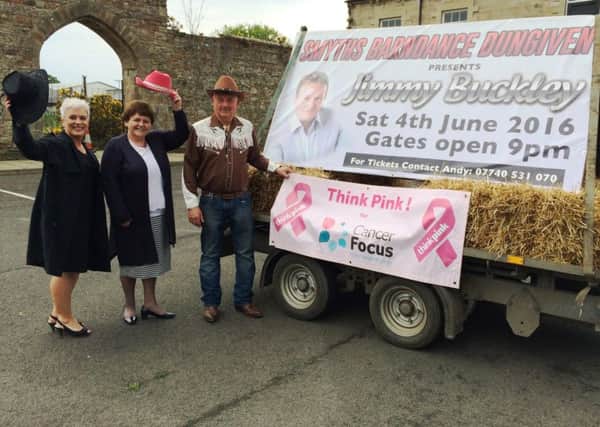 Cancer Focus NI fundraiser Emma McCann (left)  and the charitys chief executive Roisin Foster raise their hats to Andy Smyth, organiser of the Smyths Barn Dance in Dungiven