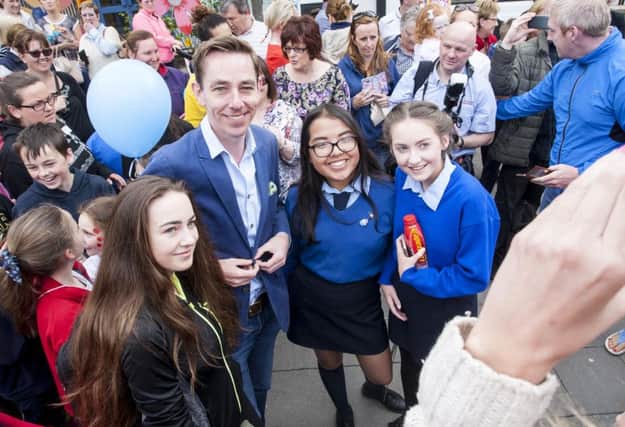 Ryan Tubridy poses for a photo with some local students during his visit to Buncrana yesterday morning. DER2216MC007