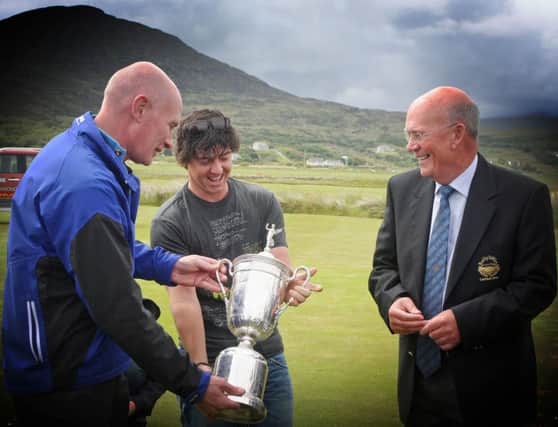 BLAST FROM PAST . . . Rory McIlroy proudly displays the U.S. Open Trophy, his first Major, to Ballyliffin Golf Clubs general manager, John Farren,  when arriving at the club back in 2011 by helicopter. Also pictured is Mr. Colm McCarroll, the 2011 Captain at the Inishowen club.