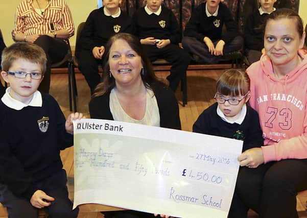 Class R2 teacher Carolyn Mussen and Laura O'Flaherty with pupils Caolan Guy-Gallagher and Caitlin Carney pictured with a cheque for Â£450 for Happy Days Children's Charity following a sponsored Dance Wiggle at Rossmar School.  INLV2116-019KDR