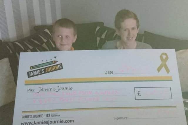 Jamie and Caolan Murphy presenting a cheque on behalf of his mum who cut off her hair and raised a staggering Â£1463.00. Caolan and his little brother are Journie kids!