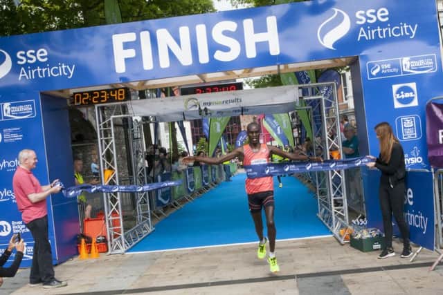 FIRST HOME!. . . Deputy First Minister Martin McGuinness holds the tape as Kenyan Eric Kiprop crosses the line in a time of 2:23:48 to win Sunday's sse Airtricity Walled City Marathon. DER2216MC035 (Photos: Jim McCafferty)