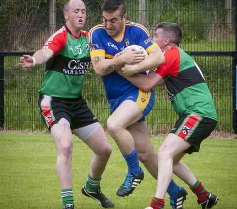Doire Trasna's Eoghan Carlin and Sean McNaught make sure there is no way through for Steelstown's Ryan Devine during Sunday's derby clash at Steelstown. DER2216MC029