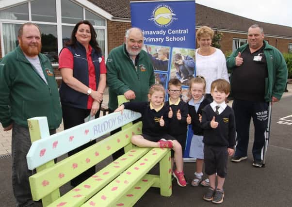 Mrs Heather Poole principal of the Limavady Central Primary School along with some of the P1 pupils are pictured receiving the first 'buddy bench' from Mags Connelly of Tesco Limavady and members of the Ballykelly Mens Shed, Andy Lee, Brian McCluskey and Barrie Jackson. INLV2216-120KDR