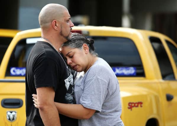 Ray Rivera, a DJ at Pulse Orlando nightclub, is consoled by a friend, outside of the Orlando Police Department after a shooting involving multiple fatalities at the nightclub, Sunday, June 12, 2016. (Joe Burbank/Orlando Sentinel via AP)
