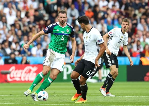 Northern Ireland's Gareth McAuley takes on Germany's Sami Khedira