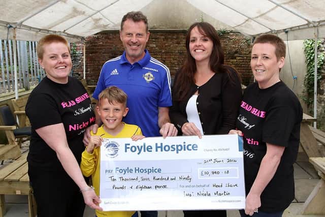 Keith Martin along with his son Jake, with Julie Tredrea and Lucinda Henry present a cheque for Â£10,790.18 in memory of Keith's wife, and Julie's sister. Collecting the cheque is Foyle Hospice community fundraiser, Michelle McGinn. Julie and Lucinda had their heads shaved, on 4th June at Limavady Rangers Supporters club. INLV2316-124KDR Photo: Ken Reay.