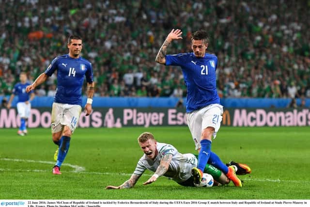 James McClean of Republic of Ireland is tackled by Federico Bernardeschi of Italy.