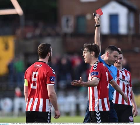 Ryan McBride, left, of Derry City is shown the red card by referee Paul McLaughlin during the SSE Airtricity League Premier Division match between Derry City and Dundalk at the Brandywell Stadium.