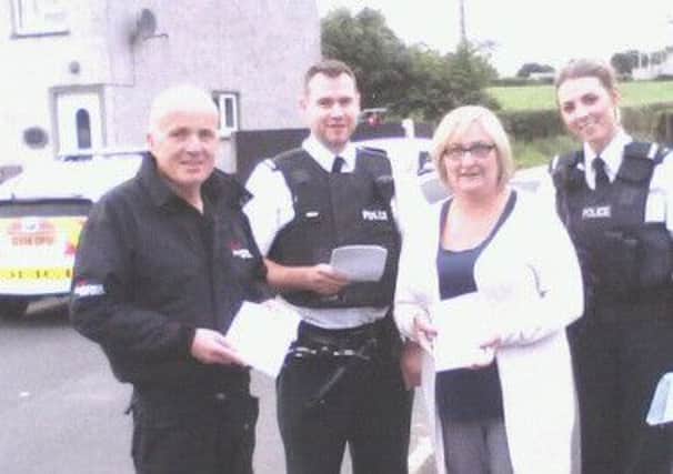 Sinn Fein councillors Sean McGlinchey and Brenda Chivers with PSNI officers in Drumsurn on Tuesday.