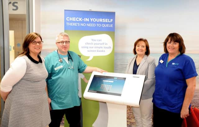 Michelle Kelly, Business Service Manager; Gavin O'Neill, Consultant in Emergency Medicine; Geraldine McKay, Director of Acute Services and Isobel McClintock, Emergency Department Manager stand with one of the two new self-check-in kiosks in Altnagelvin's Emergency Department.