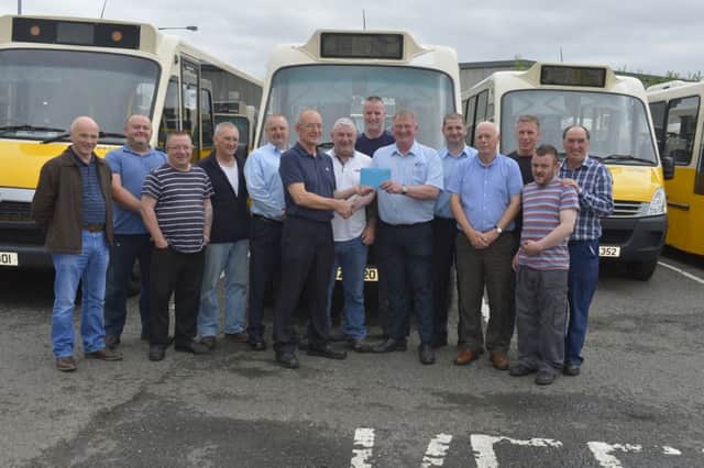 Senior WELB bus driver Martin Bryson (sixth from right) receiving a gift, on his retirement after 31 years service, from Maintenance Supervisor Tommy Meehan. In the picture are Martins colleagues including  UNITE Education and Transport representative Ciaran McCallion (fifth from right)  and Raymond Kelly (left). DER2916GS063