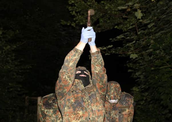 A masked and armed member of the republican dissident group  Oglaigh na h-Eireann at a show of strength in the County Derry village of Park.

Picture by Press Eye