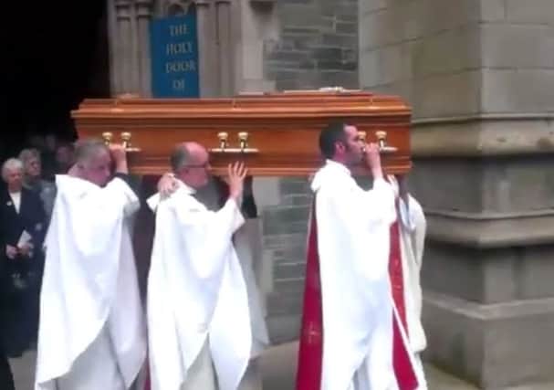 The remains of Bishop Edward Daly are carried to their final resting place after Requiem Mass in St. Eugene's Cathedral.