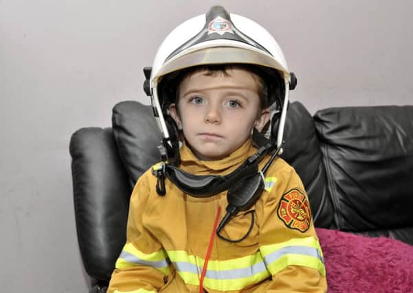 Three year old Caiden Duddy from Old School Lane wearing his Surrey Fire and Rescue Service helmet. DER3216GS053