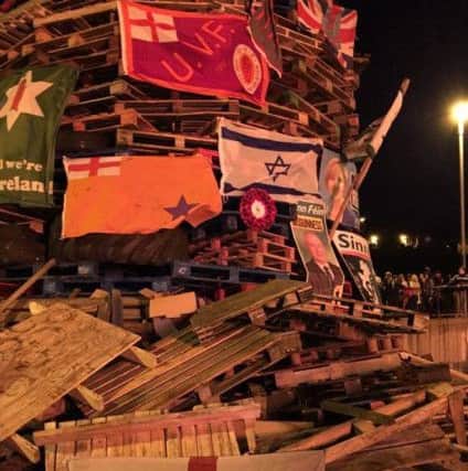 An array of loyalist flags, a poppy wretah and a Northern Ireland football supporters flag which were placed on the bonfire in the Bogside.