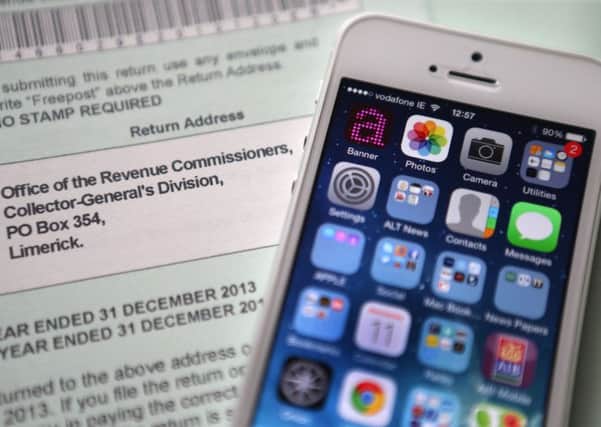An Apple iPhone beside a tax return form as the tech giant faces a huge tax bill following an EU probe into its 'sweetheart deal' with the Irish Government.