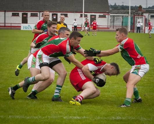 GOING NOWHERE!. . . . .Drumsurn's Pearse McNickle is surrounded by four Slaughtmanus players during Saturday's Championship game at Celtic Park. DER3616MC015 (Photo: Jim McCafferty Photography)