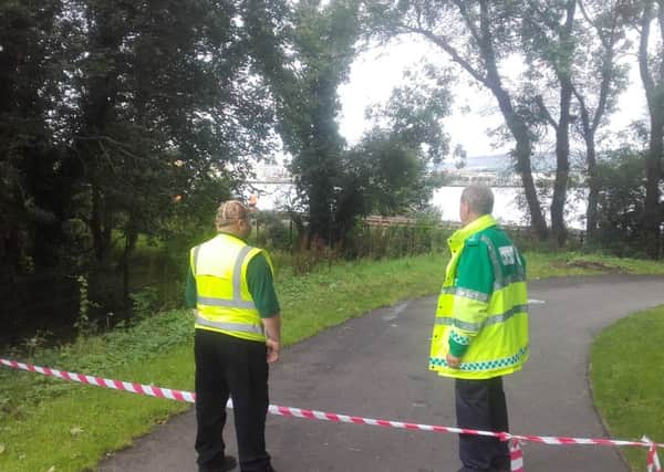 Ambulance and Council personnel gathered at the cordon close to the train at the bottom of St Columb's Park.