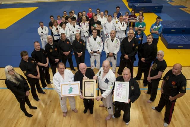 75 years-old Bernard Smith (front second from left), receives his certificates including his Black Belt 6th Dan and Teaching Diplomas in Jiu Jitsu from Josie Murray, Jim Toland and John McCaughey, Ireland's 32 Jiu Jitsu International Club at the Foyle Arena on Tuesday night. Included are club members who also received grades on the night. INLS3416MC001