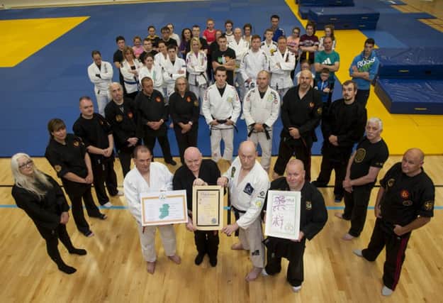 75 years-old Bernard Smith (front second from left), receives his certificates including his Black Belt 6th Dan and Teaching Diplomas in Jiu Jitsu from Josie Murray, Jim Toland and John McCaughey, Ireland's 32 Jiu Jitsu International Club at the Foyle Arena on Tuesday night. Included are club members who also received grades on the night. INLS3416MC001