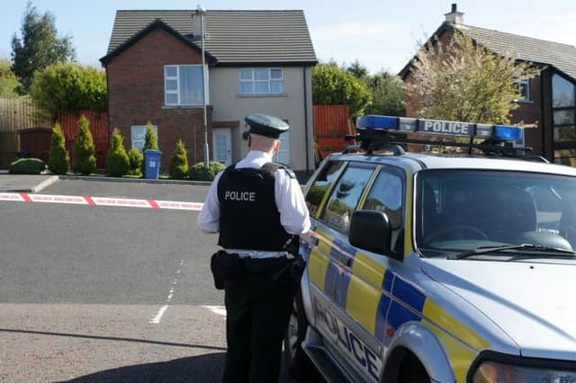 WOODSIDE HEIGHTS ATTACK. . . .A PSNI officer stands guard outside the cordon at the Woodside Heights detached house yesterday afternoon. DER1715MC088