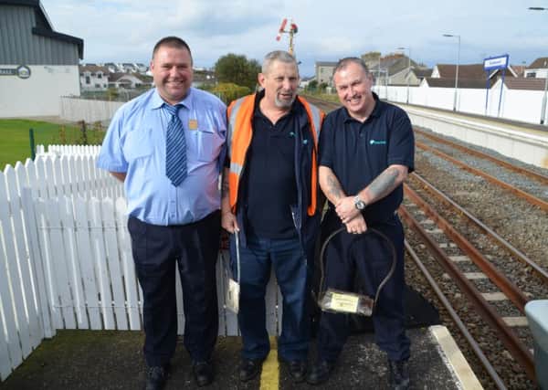 Signaller Kevin Brown is pictured with Londonderry based Train Guard Russell Craig & Driver Campbell Allen holding the single line token for the section ahead in the final few days of semaphores & token operations at Castlerock.