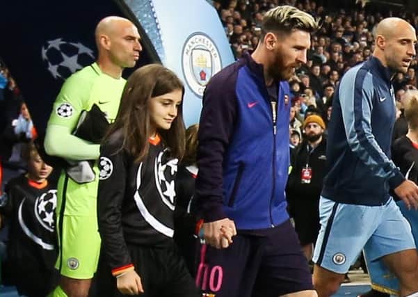 Derry girl, and Mastercard Mascot, Cara McAteer walks with Lionel Messi ahead of the UEFA Champions League match between Manchester City and FC Barcelona at the Etihad Stadium on November 1st, 2016 in Manchester.  (Photo by Barrington Coombs/Getty Images for MasterCard)