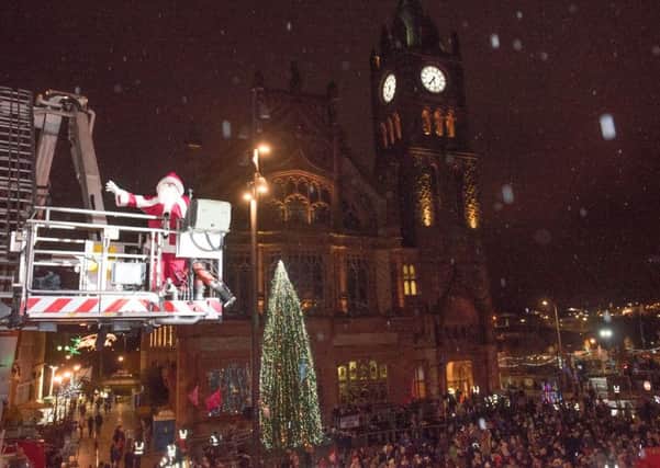 Santa flys over the crowd with the help of the Fire and Rescue Service during the Christmas Lights Switch on in Derry in Guildhall Square. Picture Martin McKeown. Inpresspics.com. 17.11.16