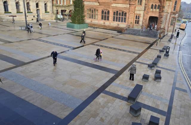 People find it difficult to walk across an icy Guildhall Square at lunch time yesterday. DER4716GS002