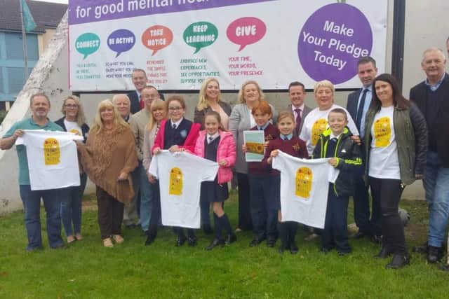Local representatives and staff with local children at the launch of the Ballymagroarty & Hazelbank Community Partnership's Mental Health Strategy.