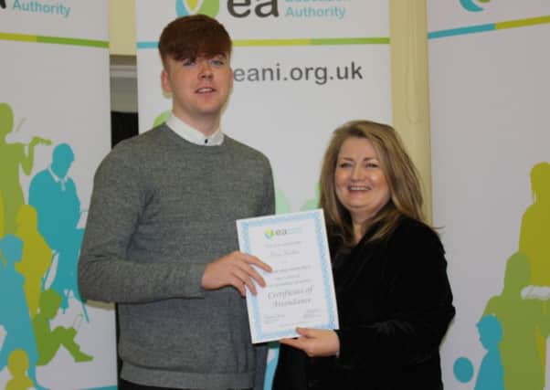 Pictured at a special EA Celebration of Full Attendance at School event, Oran Harkin, St Joseph's Boys' School, Derry is presented with his certificate by Chairperson Sharon O'Connor.