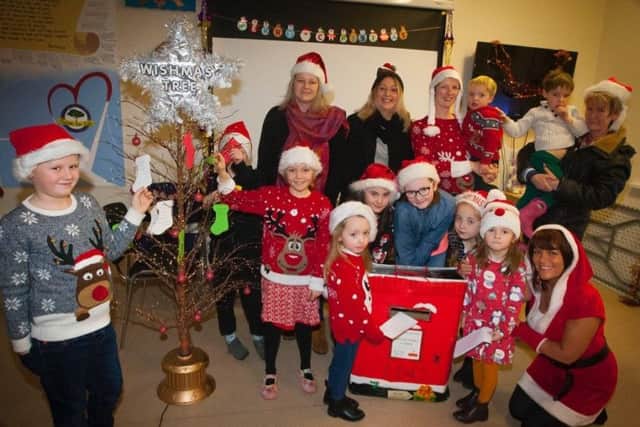 Some of the parents and children pictured at the Wishmas Tree with Margaret Cunningham.