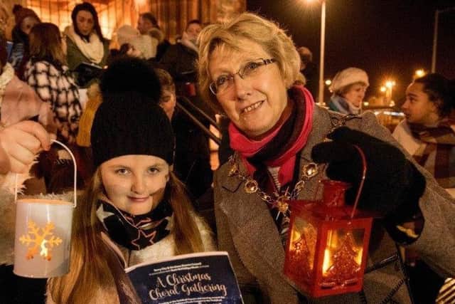 Carols by candlelight.... Mayor Hilary McClintock joins one of the young choristers who took part in the outdoor service.