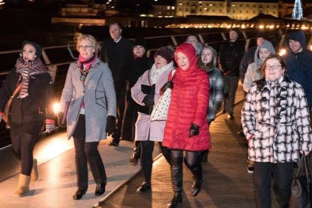 The Mayor Hilary McClintock leads singers across the Peace Bridge to join others at Guildhall Square for her Christmas Choral Gathering.
