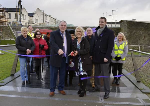 Deputy Mayor of Derry and Strabane Colr Jim McKeever, La Doice Vita Project founder Donna Maria Logue and Mark H Durkan MLA cutting a ribbon on the Peace Bridge to mark the recent first anniversary of the project supporting victims of domestic abuse. A Walk in My Shoes procession, from Ebrington Square to the City Hotel, followed the ribbon cutting. DER0117GS012
