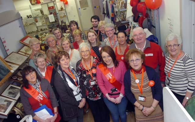 Stella Cummings (third left at front) pictured previously with volunteers at the opening of the annual  Antique and Collectables Fair at the Red Cross shop in The Diamond. (0911PG18)