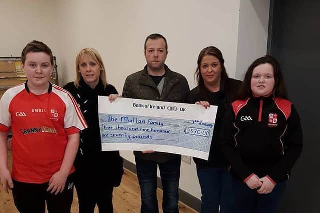 Stephen Mullan (centre) with his son Ben and daughter Leah, receiving a cheque from Kelly and Roisin Anderson and Kelly Canning. Photo: Cathy McDaid