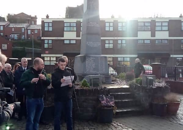 Rossa O'Dochartaigh reads the names of the dead and wounded as a lone piper plays alongside.