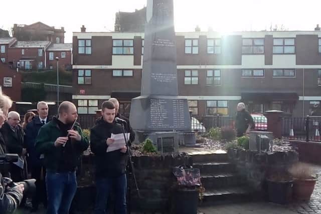 Rossa O'Dochartaigh reads the names of the dead and wounded as a lone piper plays alongside.